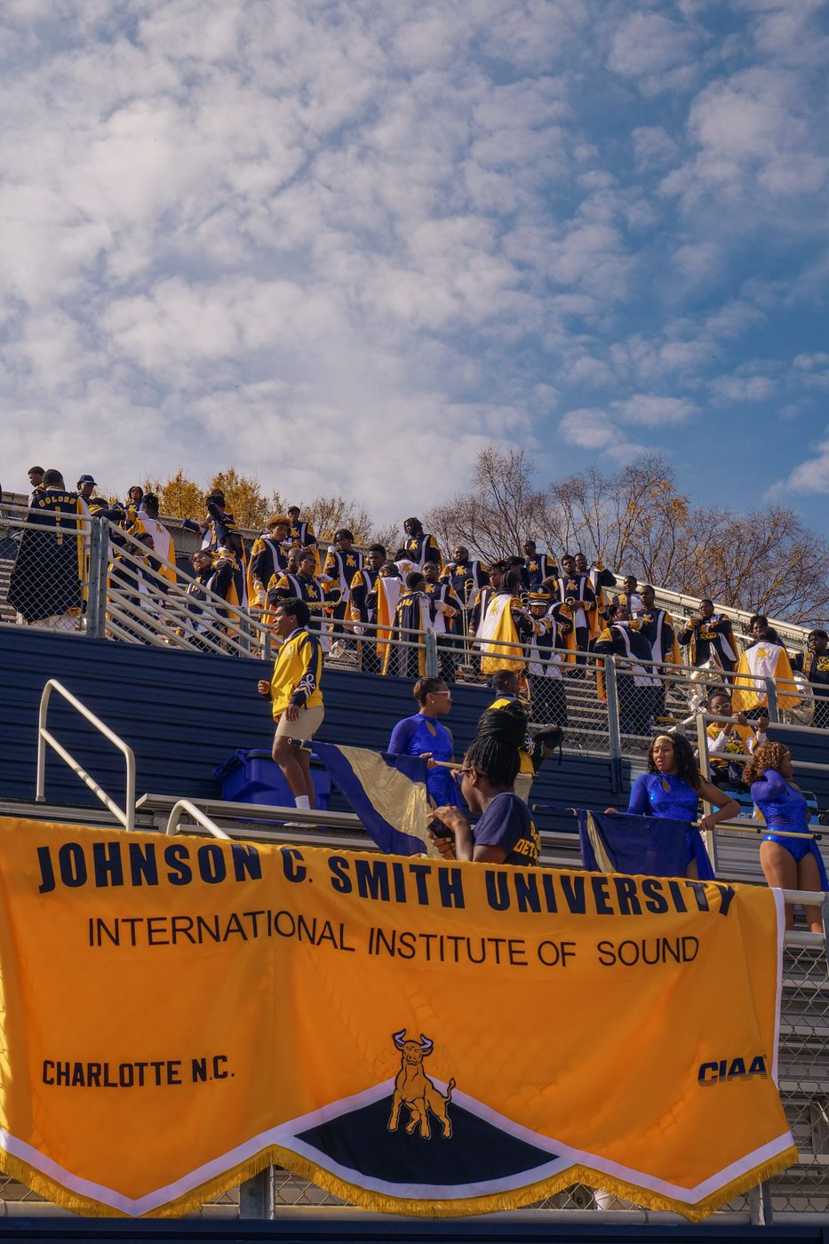 The IIOS in the stands behind the Johnson C. Smith University banner on game day